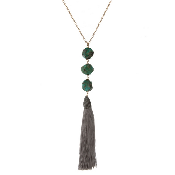Wholesale gold necklace displaying three turquoise natural stone beads gray fabr